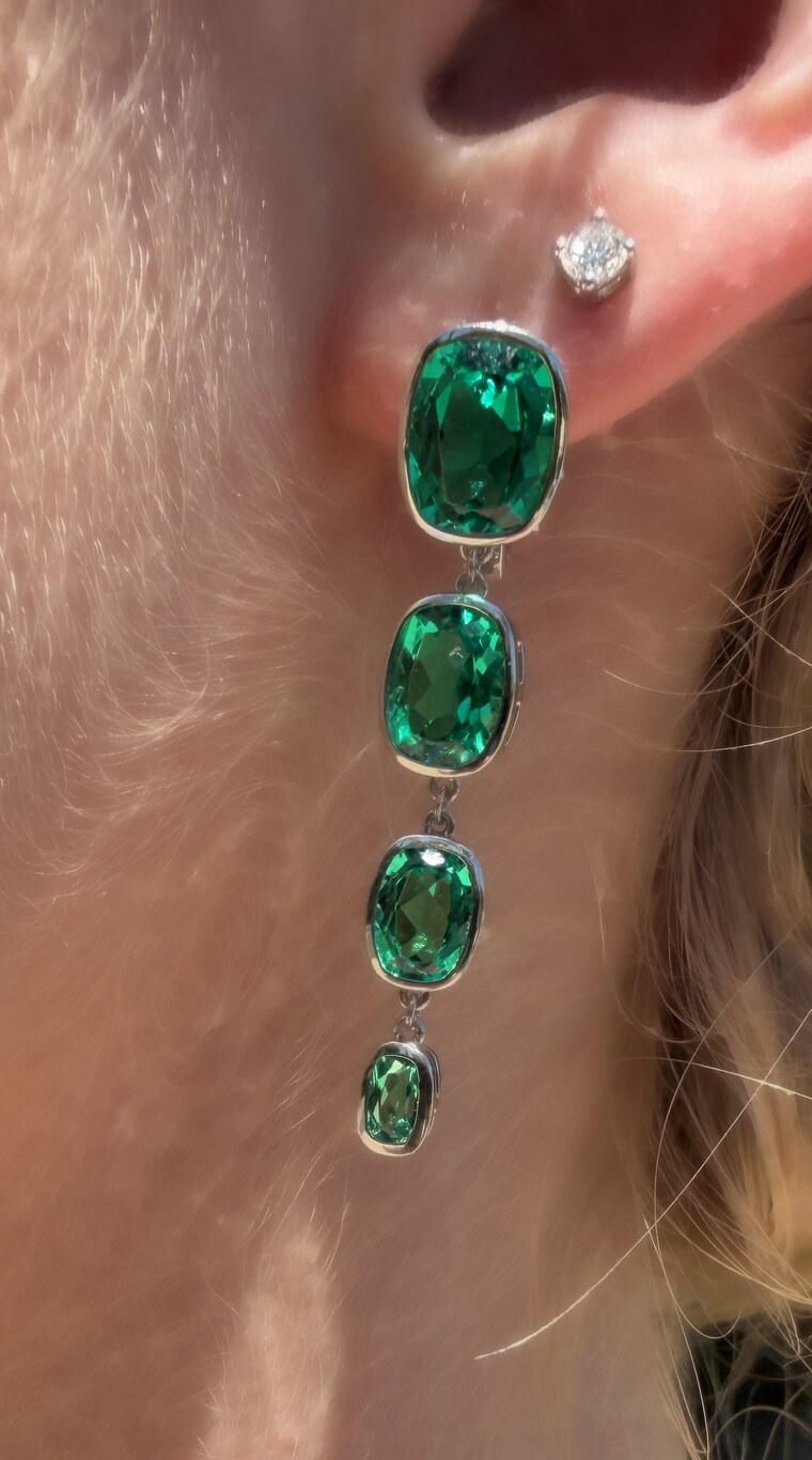 Close view of the Columbian Rain earring showing four graduated bezel-set rectangular cushion-cut lab-grown emeralds in platinum